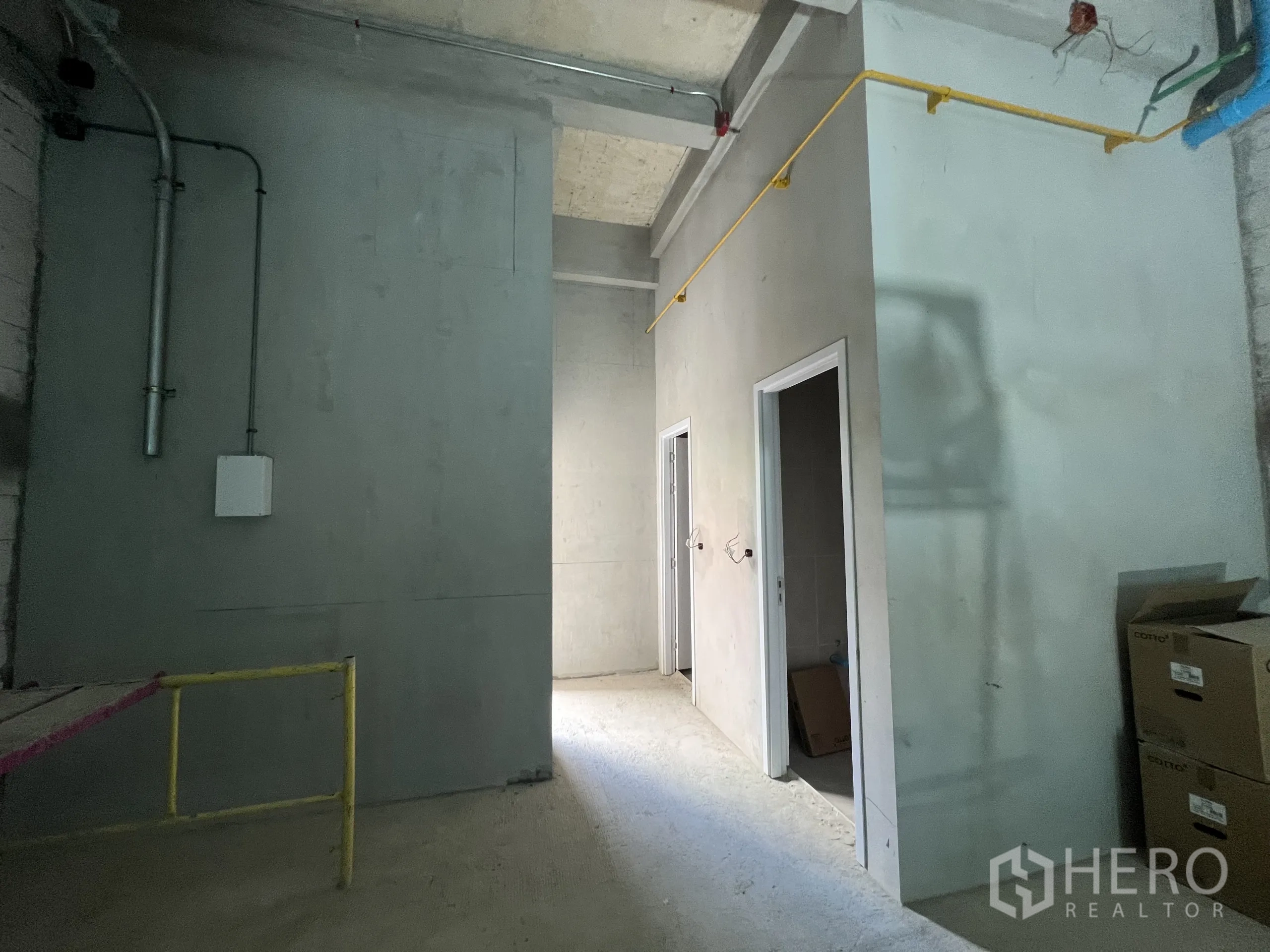 Retail Space for rent in Khlong Toei, Bangkok - Back area with two restroom doors, exposed piping and utility lines.