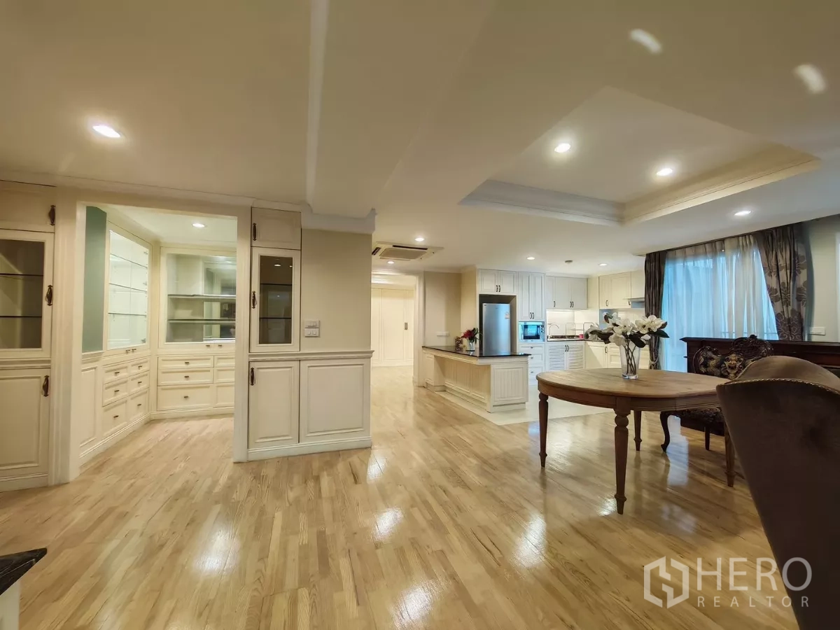 Condominium for rent in Pathum Wan, Bangkok - Spacious open-plan lounge with tray ceilings, wood flooring and display cabinetry.