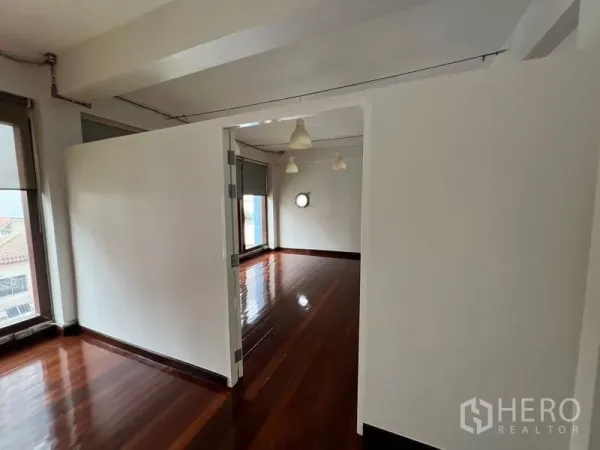 Office Space for rent in Watthana, Bangkok - Partitioned meeting room opening from the main workspace with wood floors and large windows.