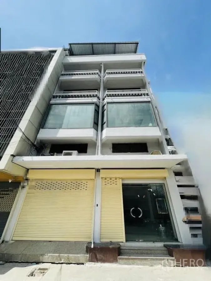 店屋 出租在Huai Khwang, Bangkok - 多层店屋外立面，楼层玻璃窗与黄色卷闸门。