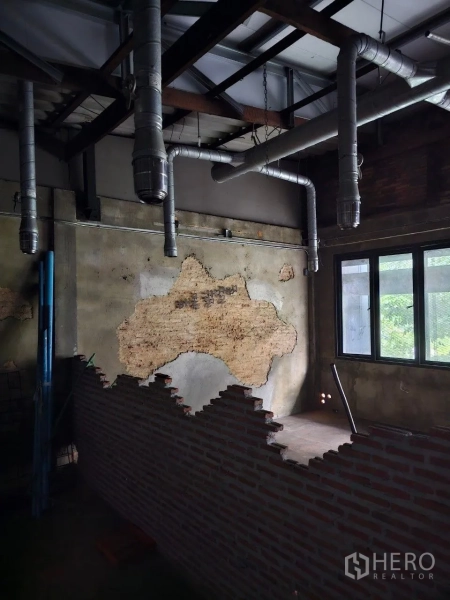 Shophouse for rent or sale in Watthana, Bangkok - Room with half-height brick divider, rough plaster wall, and multiple exhaust ducts.