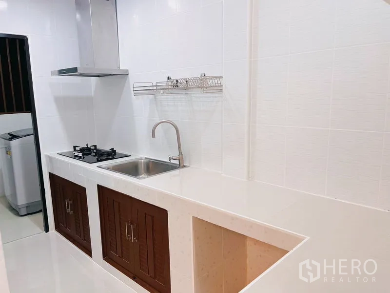 联排别墅 出租在Huai Khwang, Bangkok - 长廊厨房，带抽油烟机、水槽和电器预留位。