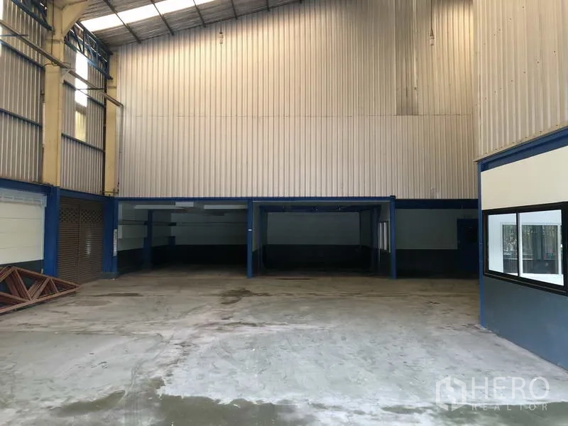 Warehouse for rent in Bang Phli, Samut Prakan - High-bay warehouse interior with metal walls, skylights, and wide open floor space.