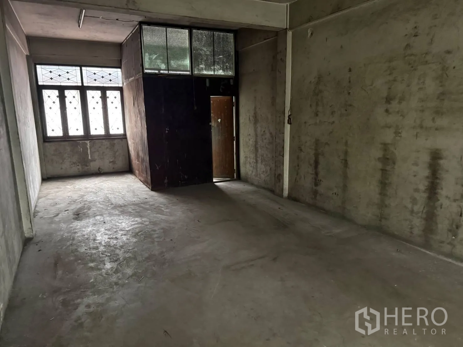 Shophouse for rent in Khlong Toei, Bangkok - Upper-floor room with frosted windows and a small partitioned cubicle.