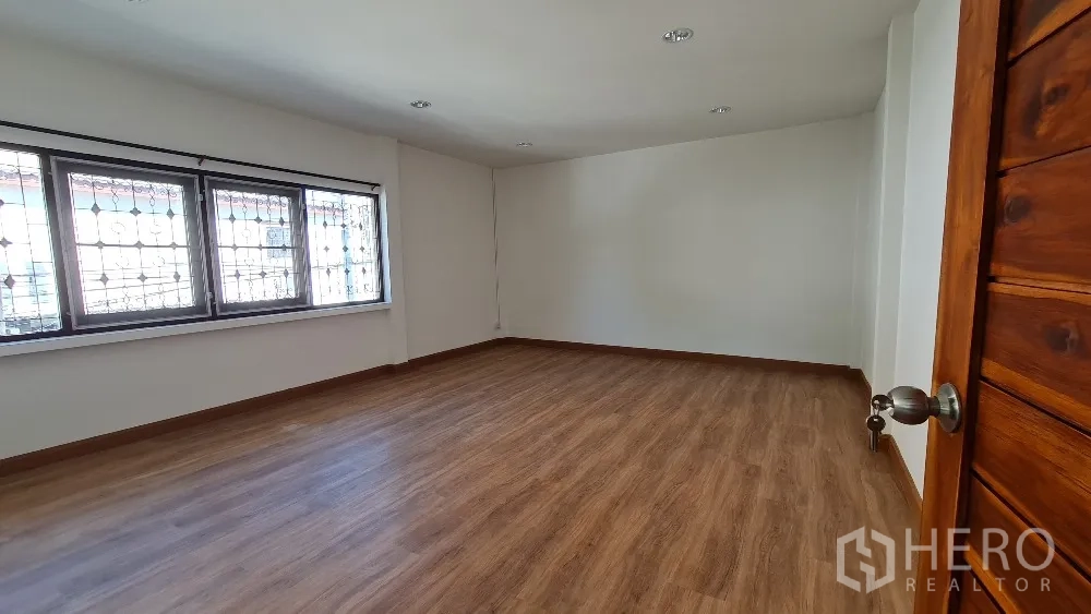 独栋房屋 for rent in Lat Phrao, Bangkok - 宽敞卧室，木地板与大面积窗户。