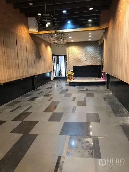 Shophouse for rent - Long shophouse hall with patterned tile floor, wood slat walls, brick feature wall and pendant lights.