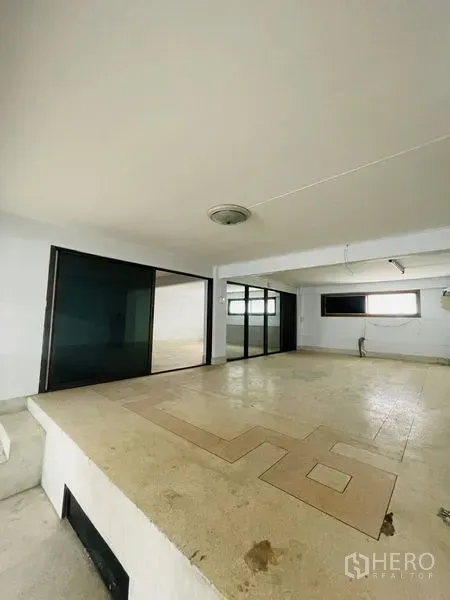 Shophouse for rent in Huai Khwang, Bangkok - Upper level workspace with raised platform and dark glass partitions.