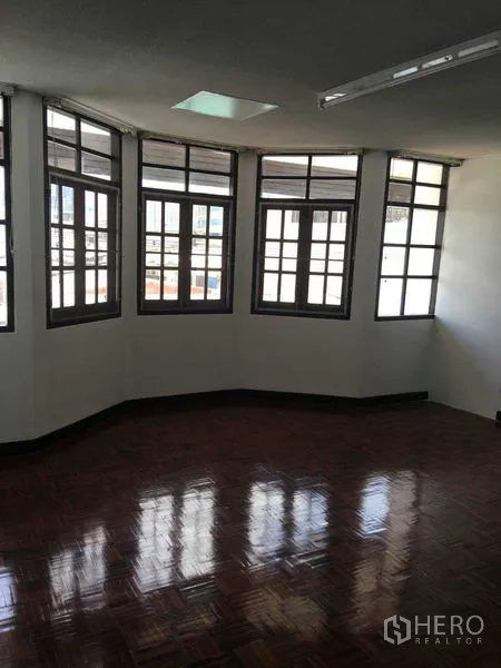 Townhouse for rent in Phra Khanong, Bangkok - Upper-floor room featuring a bay of windows and glossy parquet flooring.