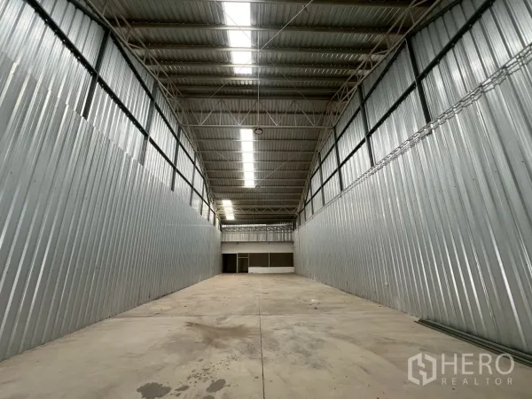 Warehouse for rent in Min Buri, Bangkok - Spacious warehouse interior with high arched roof, skylight panels, and smooth concrete flooring.