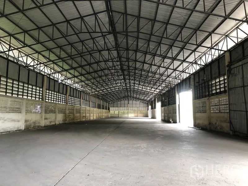 Warehouse for rent in Pathum Thani - Long clear-span interior with multiple side doors and skylight panels for natural light.