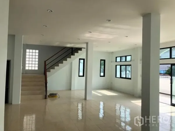 Factory for rent in Pak Kret, Nonthaburi - Bright open-plan ground floor with tiled flooring, multiple windows and a staircase.