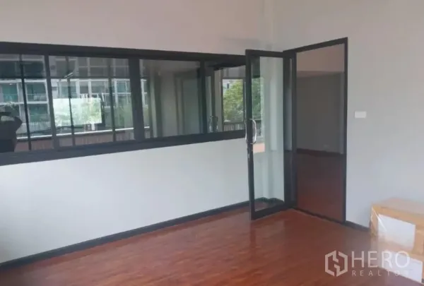 Retail Space for rent - Private room with wood flooring and a black-framed glass door opening toward the terrace.