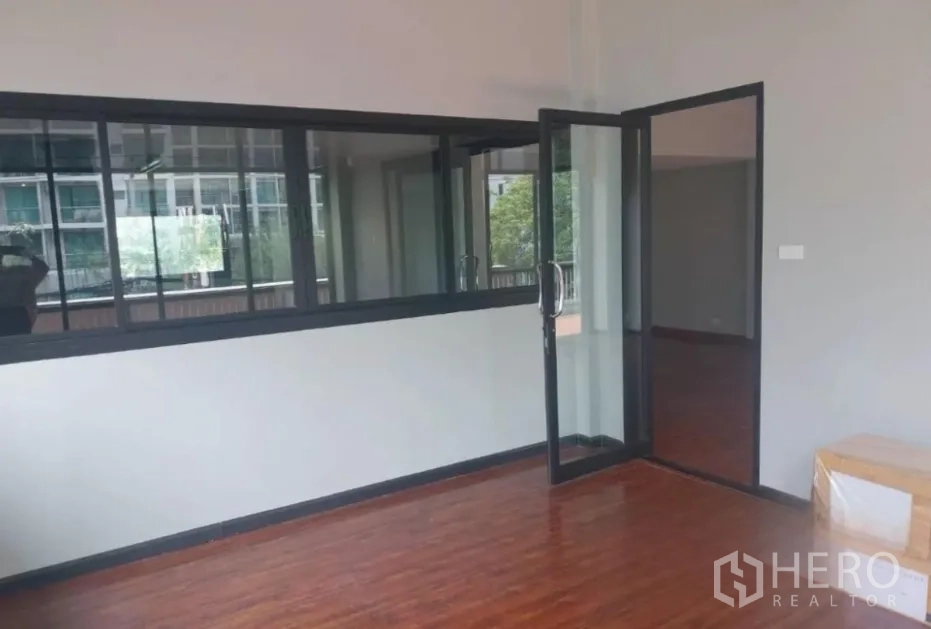 Retail Space for rent - Private room with wood flooring and a black-framed glass door opening toward the terrace.