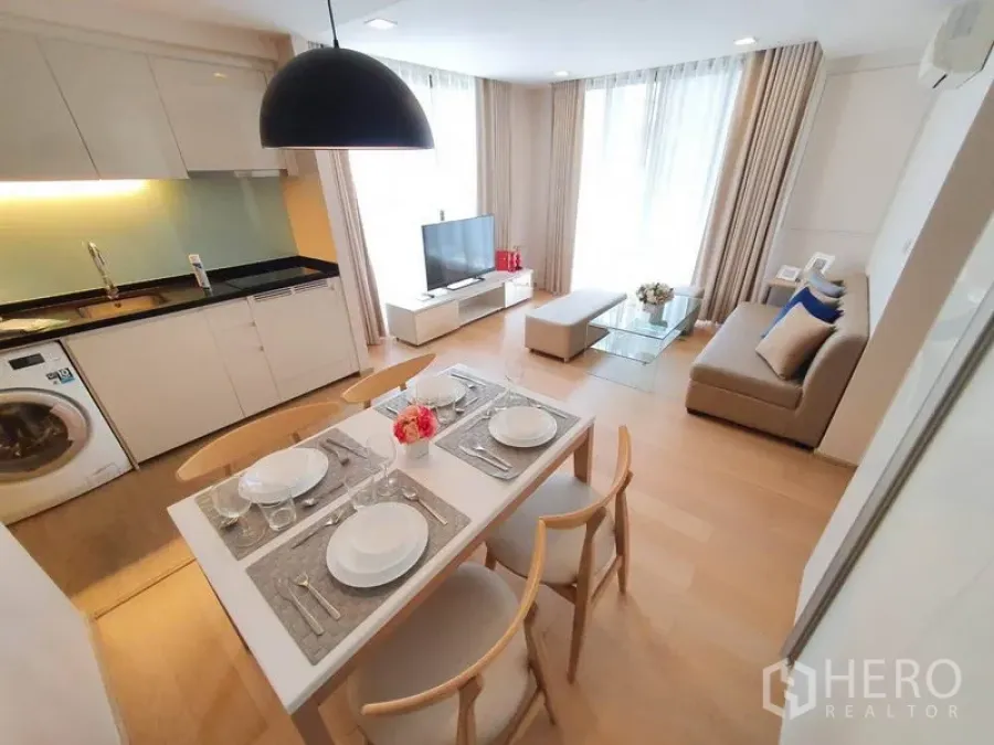 Condominium for rent in Watthana, Bangkok - Open-plan living room with dining table, TV and sleek kitchen with washer at Liv @ 49 Thonglor.