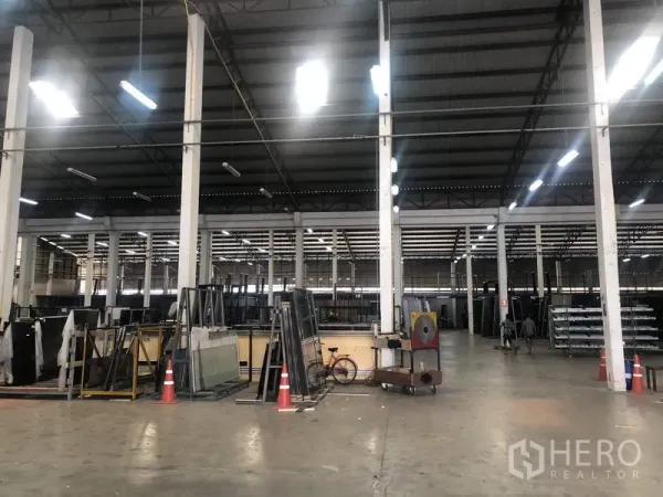 Warehouse for rent in Nonthaburi - Open storage area inside the warehouse with concrete floor, tall columns and racking.