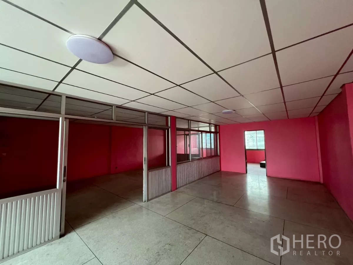 Shophouse for rent in Watthana, Bangkok - Large office area with multiple glass-partitioned rooms and tiled floor.