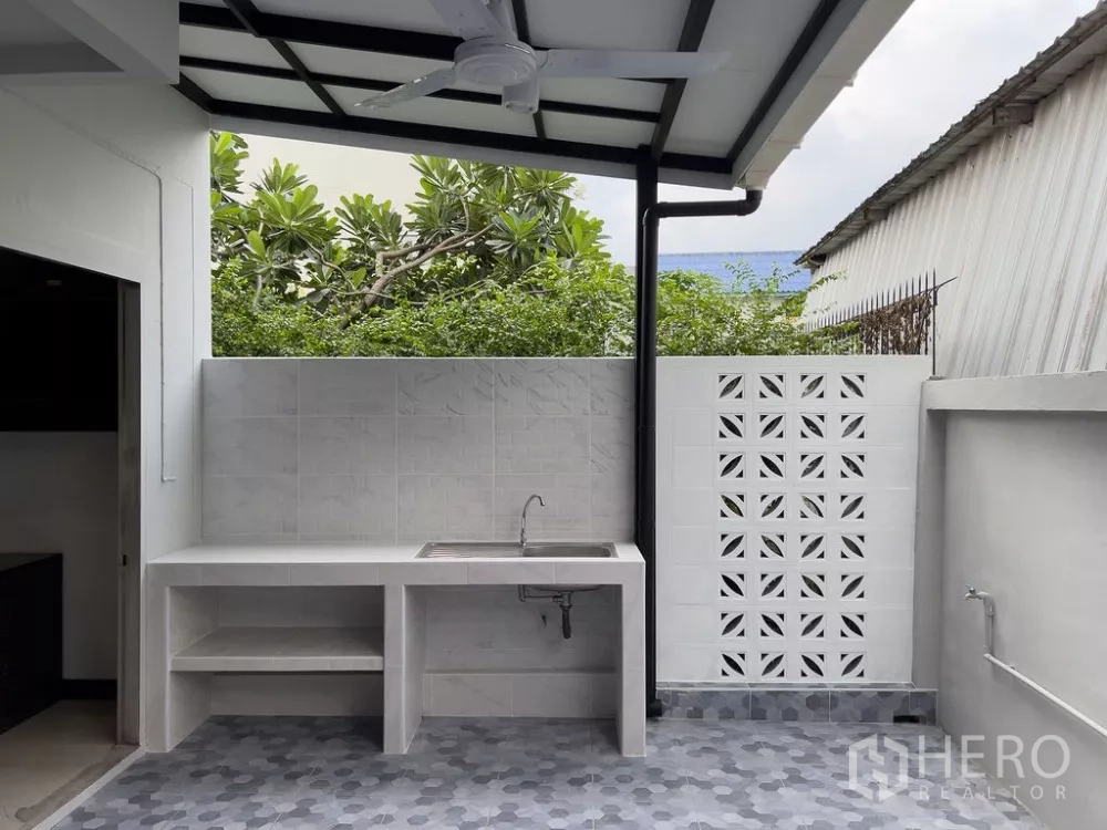 Home Office for rent in Lat Phrao, Bangkok - Close-up of tiled wash area with sink and breeze block privacy wall.