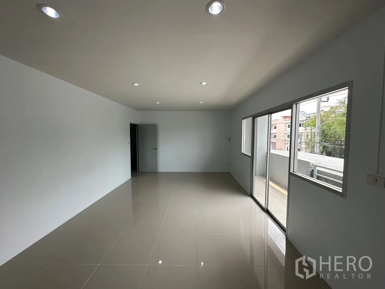 Factory for rent in Bang Bua Thong, Nonthaburi - Upper-level office room with glossy tiles and sliding glass doors to a balcony.