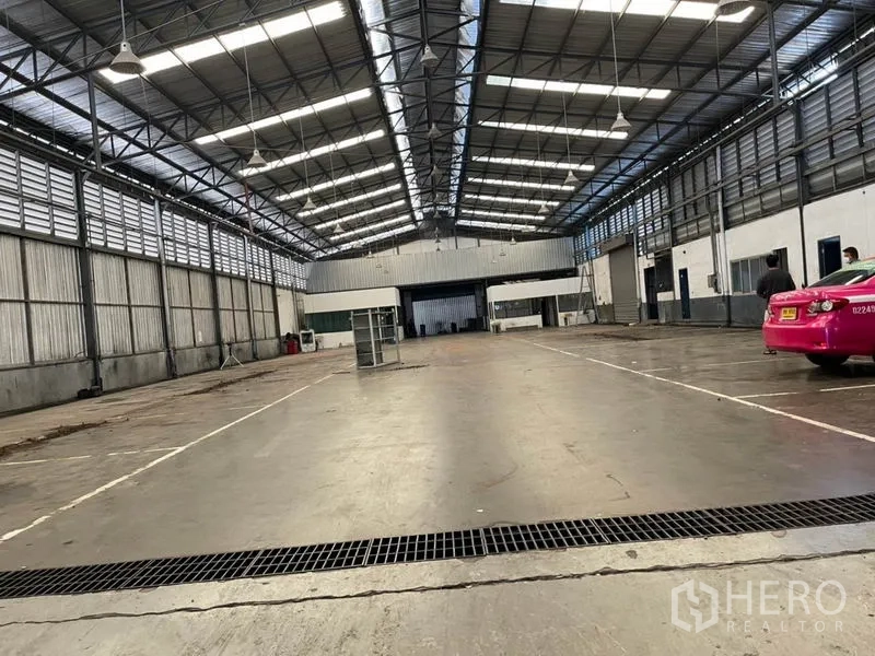 Warehouse for rent in Prawet, Bangkok - Wide warehouse bay with ventilated side panels, bright roof lights, and drive-in access.