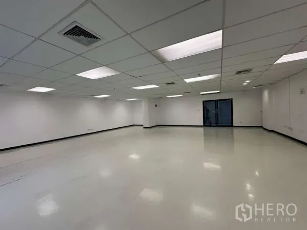 Office Space for rent - Open-plan 118 sqm office in Pathum Wan with suspended ceiling, LED panels, central air vents and glass entry doors.