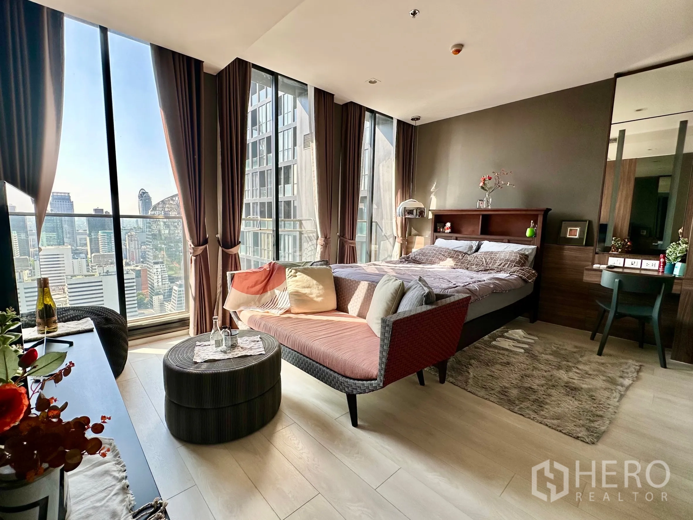 Condominium for rent in Pathum Wan, Bangkok - Bright bedroom-living area with floor-to-ceiling windows and Bangkok skyline view.