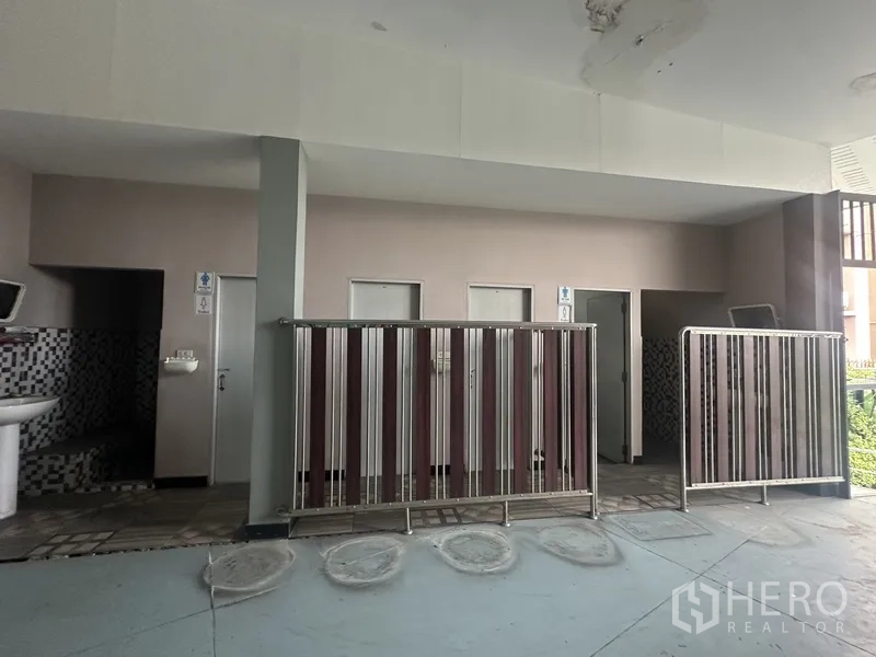 Standalone for rent in Prawet, Bangkok - Public restroom area with multiple stalls and mosaic tiled walls.