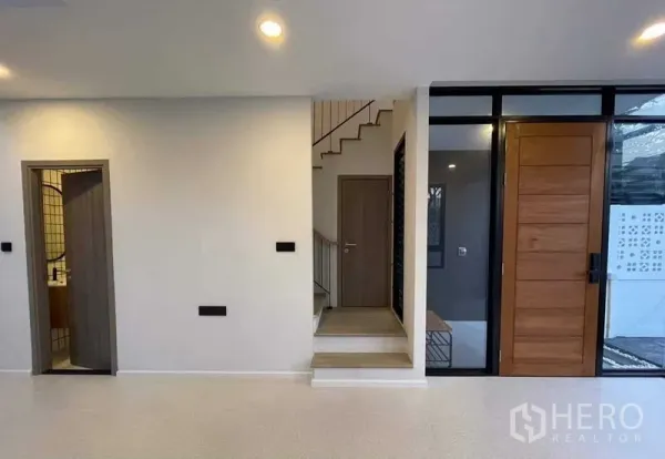 Home Office for sale in Lat Phrao, Bangkok - Entry hall with wooden front door, staircase and a guest bathroom.