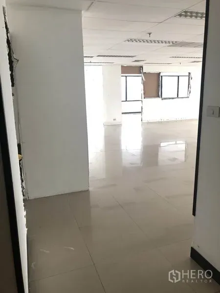 Office Space for rent in Watthana, Bangkok - Hallway opening to a large open-plan office with tiled floor and white walls.
