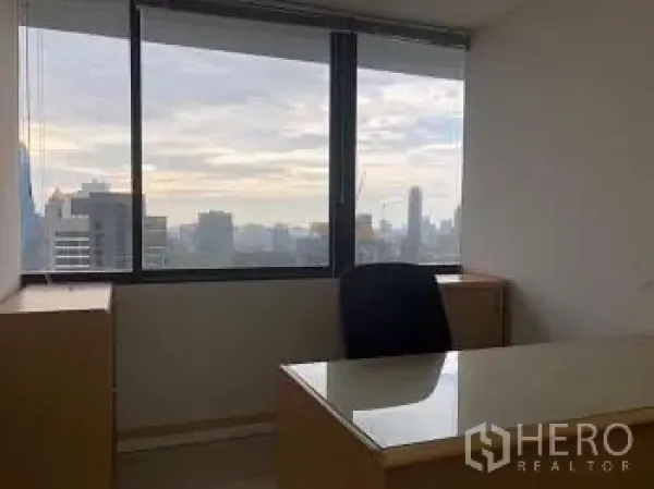 办公空间 出租或出售 - 高层办公室大窗旁的主管桌，俯瞰曼谷天际线。