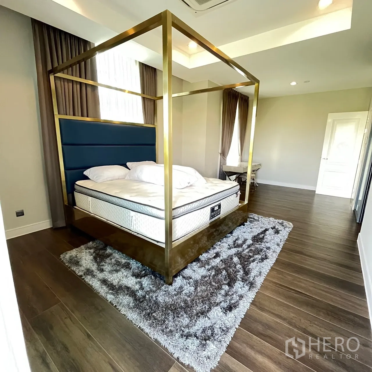 Detached House for rent or sale in Bang Khen, Bangkok - Spacious master bedroom with four‑poster bed and wood floors.