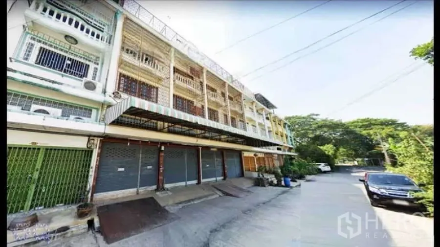 Warehouse for rent in Phasi Charoen, Bangkok - Exterior row of commercial units with roller shutter bays and small loading ramps.