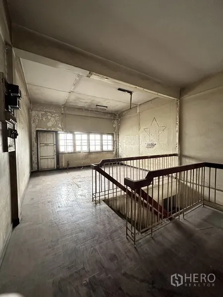 Shophouse for rent or sale in Watthana, Bangkok - Upper room with large windows and aged walls ready for refurbishment.