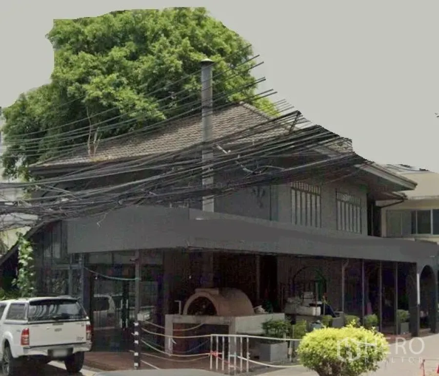 Retail Space for rent in Watthana, Bangkok - Two-storey corner retail building with wide glass frontage, covered terrace and an outdoor brick-oven feature in Watthana, Bangkok.