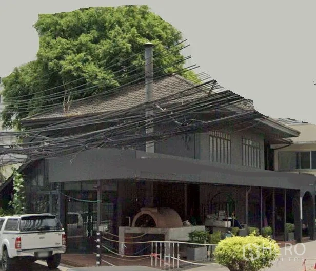 Retail Space for rent in Watthana, Bangkok - Two-storey corner retail building with wide glass frontage, covered terrace and an outdoor brick-oven feature in Watthana, Bangkok.