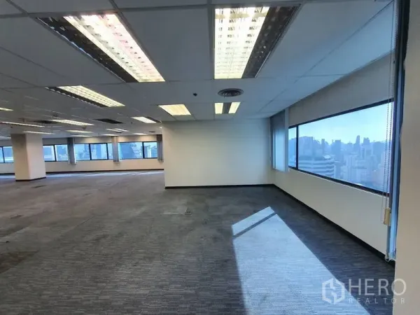 Office Space for rent in Watthana, Bangkok - Expansive open‑plan office with carpet tiles and wide windows showing the city skyline.