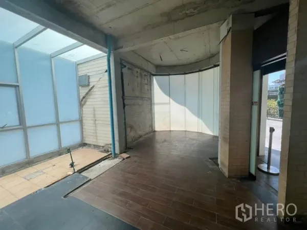 Retail Space for rent in Watthana, Bangkok - Entry area showing brick columns, wood-look tiles, and daylight from side glazing.