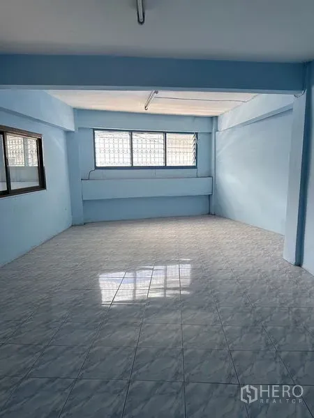 Shophouse for rent in Bang Na, Bangkok - Bright upper-floor room with large windows and glossy tiled floor.