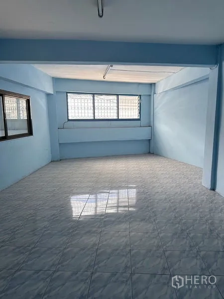 Shophouse for rent in Bang Na, Bangkok - Bright upper-floor room with large windows and glossy tiled floor.