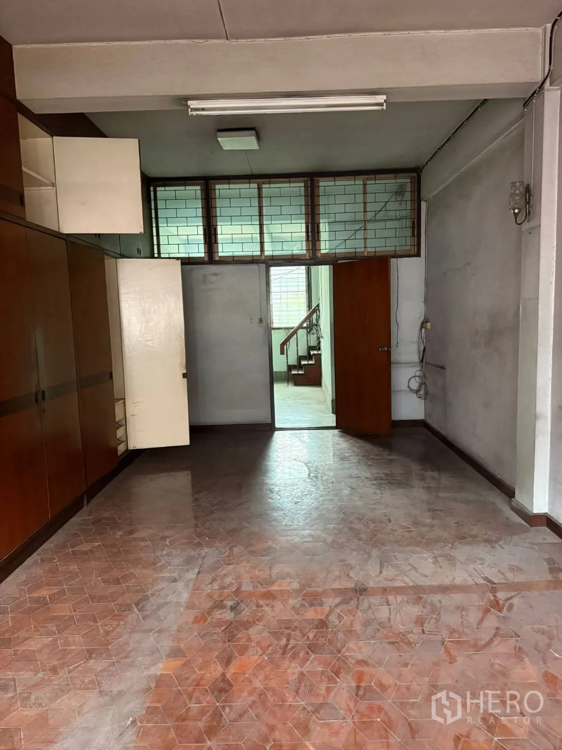 Shophouse for rent in Khlong Toei, Bangkok - Room with built-in cabinetry, open shelving, and a doorway to the stair hall.