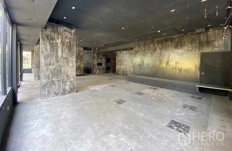 Retail Space for rent in Khlong Toei, Bangkok - Spacious shop floor with glazed frontage, feature wall and raised platform.