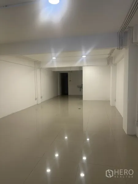 Retail Space for rent - Bright open-plan retail interior with glossy tile flooring, white walls, and ceiling lights.