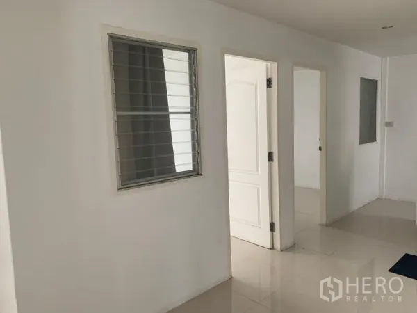 Townhouse for rent in Din Daeng, Bangkok - Upstairs corridor with louvered windows and white interior doors in a renovated townhouse.