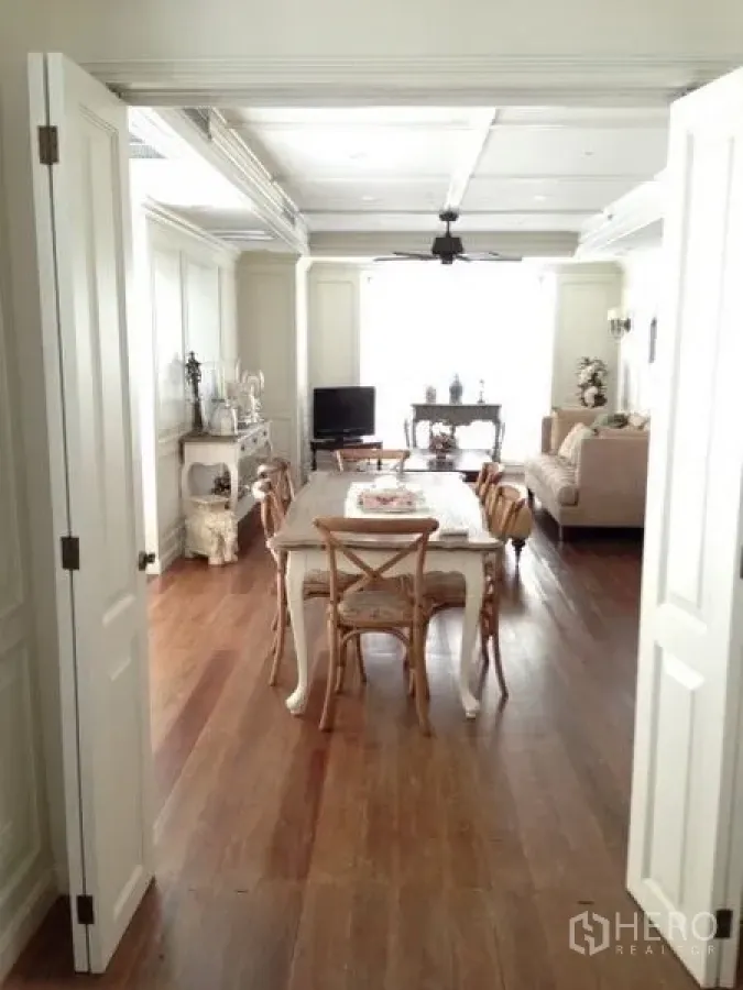 Condominium for rent in Pathum Wan, Bangkok - Bright living and dining room with coffered ceiling, white paneling and warm wooden floors.