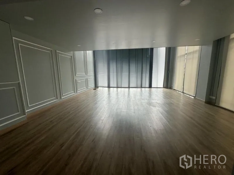 Home Office for rent in Suan Luang, Bangkok - Ground-floor showroom space with tall windows and roller shades.