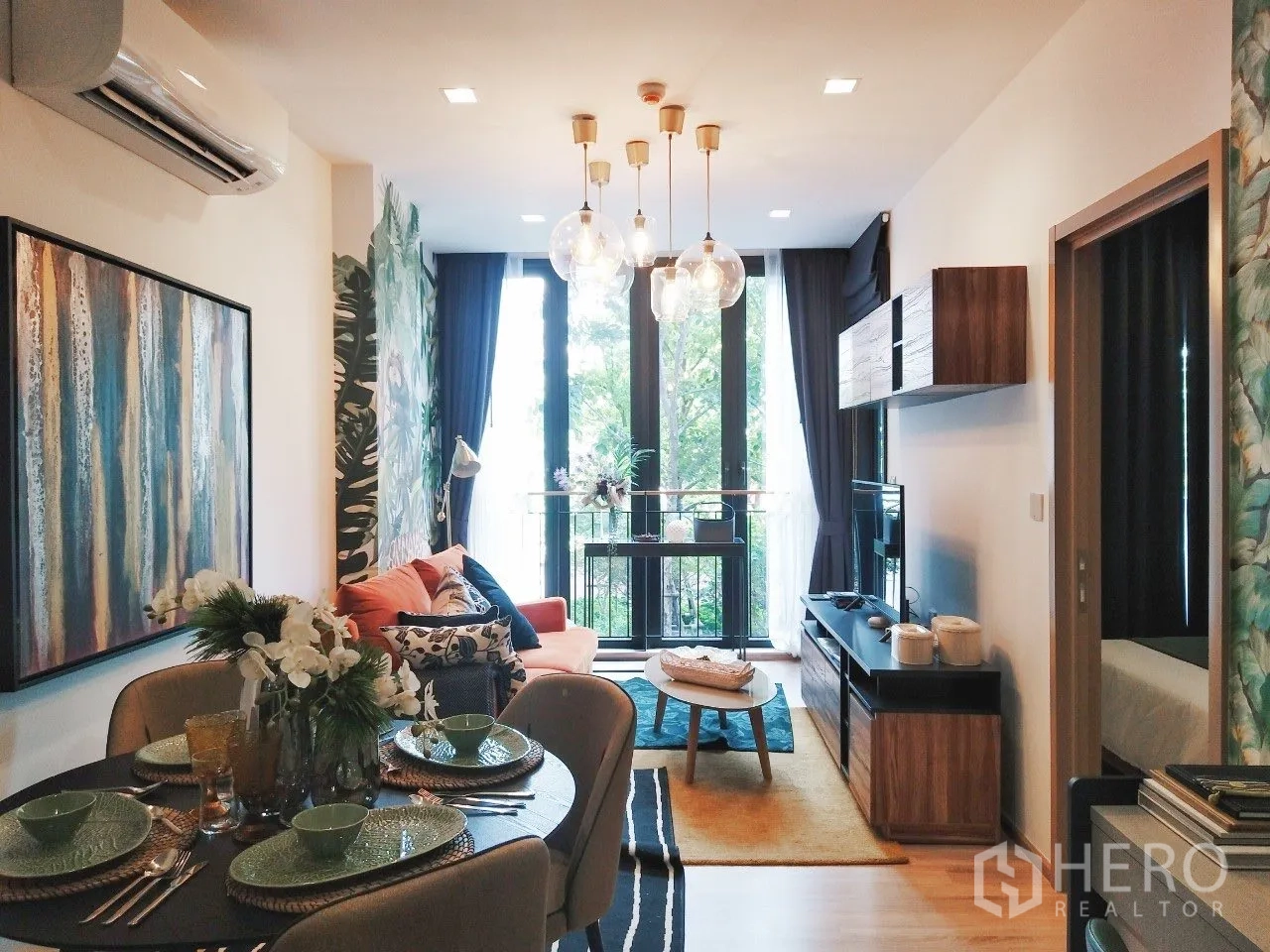 Condominium for rent in Watthana, Bangkok - Bright living and dining area with tall windows, sofa, TV unit, and set table.