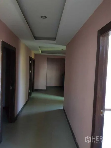 办公空间 出租在Phra Khanong, Bangkok - 室内长走廊，吊顶与多个房间门口。