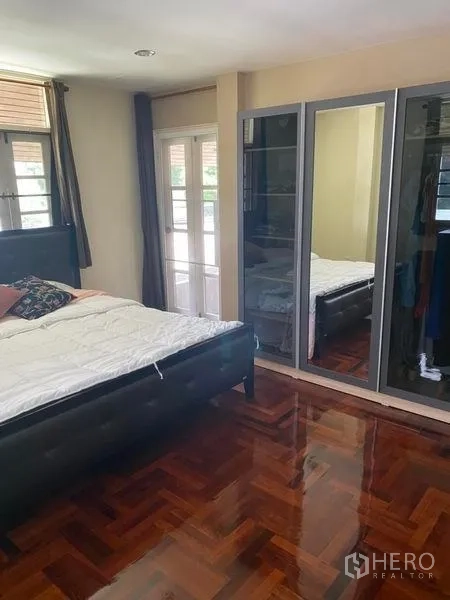 Detached House for rent in Khlong Toei, Bangkok - Bedroom with bed, mirrored wardrobe and door to small balcony.