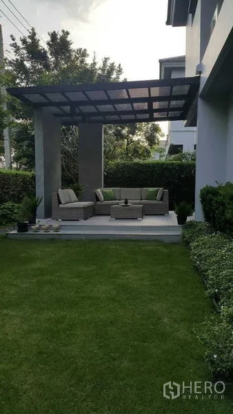 Detached House for rent in Prawet, Bangkok - Covered outdoor pavilion with wicker sofas overlooking a neat lawn.