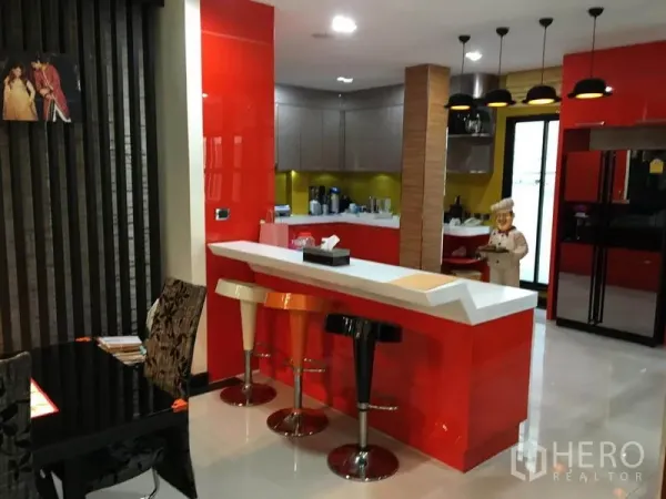 独立式住宅 出租在Khlong Toei, Bangkok - 现代厨房，红色橱柜与早餐吧台，高脚凳和吊灯。