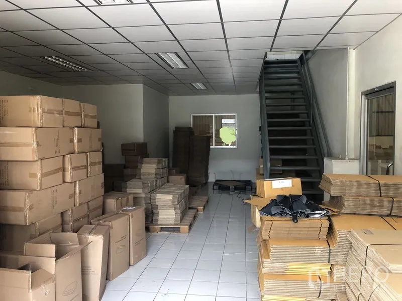 工厂 出租在Khlong Luang, Pathum Thani - 一层办公室/打包区，地砖地面、日光灯照明，并设楼梯通往二层。